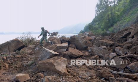 Prajurit TNI berjalan di sekitar bukit yang longsor akibat gempa di kawasan Kintamani, Bangli, Bali, Sabtu (16/10/2021). Gempa bumi dengan magnitudo 4,8 SR terjadi di darat pada jarak delapan kilometer barat laut Karangasem dengan kedalaman 10 km pada Sabtu (16/10) pukul 04.18 Wita. 