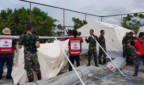 Prajurit TNI bersama dengan Palang Merah Indonesia (PMI) dan relawan membangun hunian sementara di wilayah Balaroa, Palu Barat, Palu, Sulawesi Tengah (Sulteng), Sabtu (13/10). 