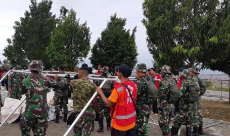 Prajurit TNI bersama dengan Palang Merah Indonesia (PMI) dan relawan membangun hunian sementara di wilayah Balaroa, Palu Barat, Palu, Sulawesi Tengah (Sulteng), Sabtu (13/10). 