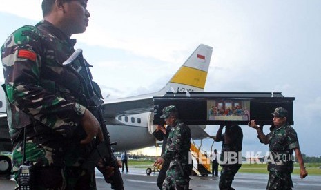 Prajurit TNI dan Polri mengusung peti jenazah korban KKB di Bandara Moses Kilangin Timika, Mimika, Papua, Jumat (7/12)