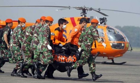  Prajurit TNI dan tim Basarnas membawa sebuah kantong yang berisi jenazah korban kecelakaan pesawat Sukhoi Super Jet 100 menuju mobil ambulance di Bandara Halim Perdanakusuma, Jakarta, Sabtu (12/5).