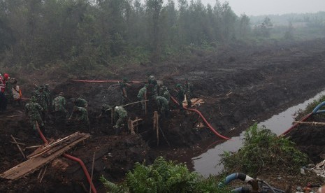 Prajurit TNI dikerahkan untuk membuat sekat kanal di lahan yang terbakar.