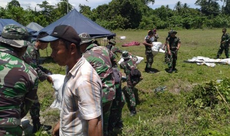 Prajurit TNI gabungan dari Pasmar 1 Jakarta dan Pasmar 2 Surabaya  yang tergabung dalam Kogasgabpad Penanggulangan Bencana gempa bumi, tsunami dan likuifaksi Palu, Sulawesi tengah, bahu membahu bersama masyarakat mendirikan tenda-tenda pengungsi di Desa Labean Kecamatan Balesang, Donggala, Senin (22/10). 