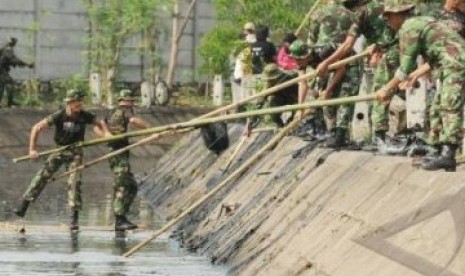 Prajurit TNI Kodam VII/Wirabuana saat kerja bhakti membersihkan kanal.