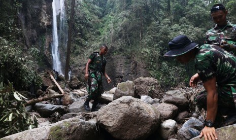 Prajurit TNI melakukan proses pencarian korban banjir bandang dilokasi wisata Air Terjun Dua Warna, Sibolangit, Deli Serdang, Sumatera Utara, Selasa (17/5).