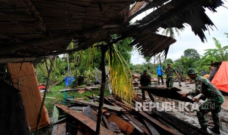 Prajurit TNI membantu membersihkan bangunan rumah warga yang rusak akibat angin puting beliung di Desa Matang Sijuek Timu, Kecamatan Baktiya Barat, Aceh Utara, Aceh, Ahad (26/2).