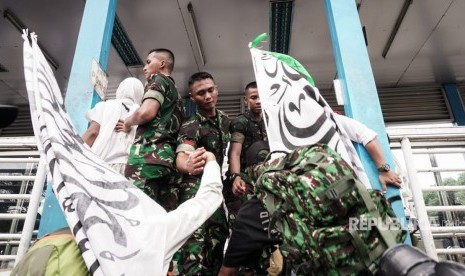 Prajurit TNI membantu peserta kegiatan Reuni 212 yang hendak menyeberang ke Stasiun Juanda, Jakarta Pusat, dari Masjid Istiqlal, Jakarta Pusat, Ahad (2/12). Peserta kegiatan Reuni 212 harus melompat ke halte bus Transjakarta untuk bisa cepat sampai ke Stasiun Juanda.