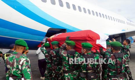 Prajurit TNI membawa peti jenazah Babinsa Koramil 1702-07/Kurulu Sertu Eka Adriyanto Hasugian bersama istri Sri Lestari Indah Putri untuk dimasukkan ke pesawat di Bandara Wamena, Papua, Jumat (1/4/2022). Sertu Eka bersama istri yang menjadi korban penembakan dan penyerangan orang tak dikenal (OTK) di Elelim Kabupaten Yalimo, Papua pada Kamis (31/3/22) diterbangkan ke Jawa Timur untuk dimakamkan. 