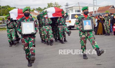 Prajurit TNI membawa peti jenazah Babinsa Koramil 1702-07/Kurulu Sertu Eka Adriyanto Hasugian bersama istri Sri Lestari Indah Putri untuk dimasukkan ke pesawat di Bandara Wamena, Papua, Jumat (1/4/2022). Sertu Eka bersama istri yang menjadi korban penembakan dan penyerangan orang tak dikenal (OTK) di Elelim Kabupaten Yalimo, Papua pada Kamis (31/3/22) diterbangkan ke Jawa Timur untuk dimakamkan. 