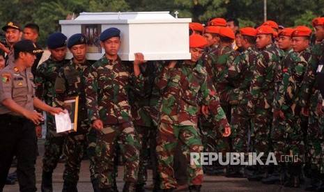 Prajurit TNI mengangkat peti jenazah korban penembakan kelompok kriminal bersenjata (KKB) yang tiba di Landasan Udara Hasanuddin, Kabupaten Maros, Sulawesi Selatan, Jumat (7/12). Sebanyak 16  jenazah korban penembakan KKB di Nduga dipulangkan dan  diserahterimakan kepada pihak keluarga.