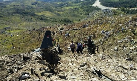 Prajurit TNI, Polri dan warga mengevakuasi puing pesawat Hercules yang jatuh di kawasan Gunung Lisuwa, Kampung Maima, Distrik Minimo, Kabupaten Jayawijaya, Minggu (18/12). 