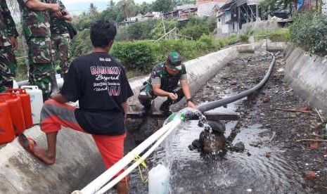 Prajurit TNI turut membantu warga Lombok memperbaiki instalasi air bersih yang rusak dan tertimbun material longsor pascagempa bumi di Lombok, Nusa Tenggara Barat, beberapa waktu lalu. 