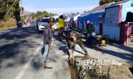 Prajurit TNI yang tergabung dalam Kogasgabpad Rehabilitasi dan Rekonstruksi  bersama-sama warga bahu membahu memperbaiki pipa saluran air bersih sepanjang 6 km yang rusak akibat gempa di Kecamatan Sembalun, Kabupaten Lombok Timur, Senin (22/10).