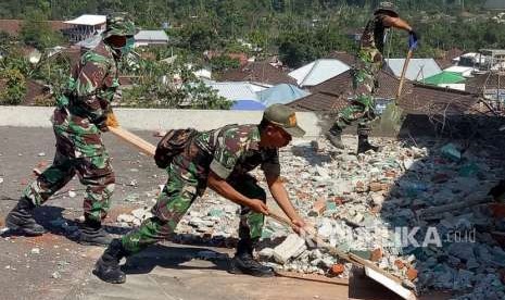 Prajurit TNI yang tergabung dalam Komando Tugas Gabungan Terpadu (Kogasgabpad) bersama warga membongkar dan membersihkan puing-puing Masjid Al-Abror di Dusun Wadon,  Desa Kekait,Kecamatan Gunung Sari, Lombok Barat, Senin (24/9).