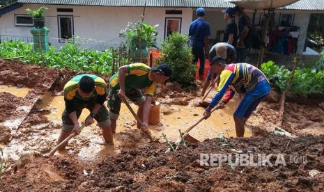 Prajurit Yonif Raider 323 Kostrad membantu korban bencana alam banjir dan tanah longsor di Pangandaran.