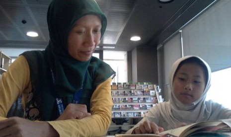 Pratiwi menemani putrinya Adzra membaca di sebuah perpustakaan di Melbourne.