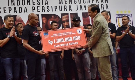 Presdir PT Freeport Indonesia Chappy Hakim (kanan) menyerahkan bonus secara simbolis kepada Ketua Umum Persipura Jayapura Benhur Tomi Mano (kedua kiri) disaksikan pemain dan ofisial Klub Persipura Jayapura di Jakarta, Jumat (6/1). 