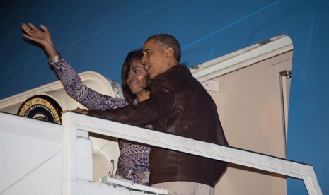 Presiden AS Barack Obama dan Ibu Negara Michelle Obama melambaikan tangan saat menaiki pesawat Air Force One di Buenos Aires sebelum bertolak ke Washington, Kamis, 24 Maret 2016.