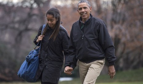 Presiden AS Barrack Obama menggandeng tangan putri tertuanya, Malia.