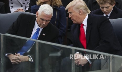 Presiden AS Donald Trump berbincang dengan wakil presiden Mike Pence dalam upacara inagurasi di Gedung Capitol, Washington DC, Jumat (20/1).