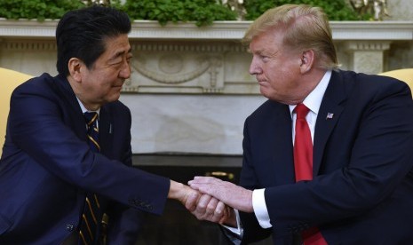 Presiden AS Donald Trump berjabat tangan dengan perdana menteri Jepang Shinzo Abe di Gedung Putih, Washington, AS, Jumat (26/4) waktu setempat. 