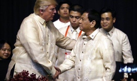 Presiden AS Donald Trump berjabat tangan dengan Presiden Filipina Rodrigo Duterte saat makan malam KTT ASEAN di SMX Convention Center, Ahad (12/11).