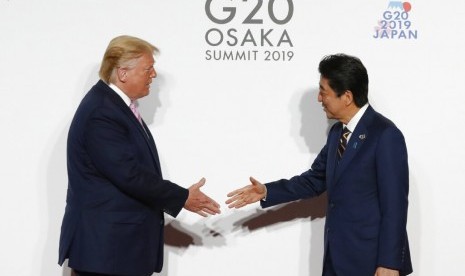 Presiden AS Donald Trump dan Perdana Menteri Jepang Shinzo Abe dalam sesi foto Konferensi Tingkat Tinggi (KTT) G-20 di Osaka, Jepang, Jumat (28/6).