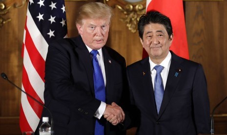 Presiden AS Donald Trump (kiri) berjabat tangan dengan Perdana Menteri Jepang Shinzo Abe di Akasaka Palace, Senin (6/11).