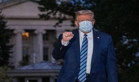 Presiden AS Donald Trump mengepalkan tangan saat keluar dari Walter Reed Medical Center, Senin (5/10). 