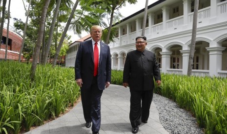 Presiden AS Donald Trump saat berjalan dengan pemimpin Korea Utara Kim Jong-un di Hotel Capella di Pulau Sentosa Singapura, Selasa (12/6).