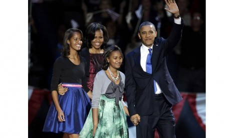 Presiden Barack Obama didampingi keluarganya melambaikan tangan kepada para pendukungnya usai berpidato di Chicago, Rabu (7/11).   (AP/Charles Rex Arbogast)