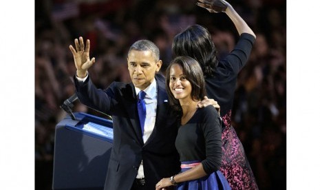 Presiden Barack Obama melambaikan tangan bersama putrinya Malia usai berpidato di Chicago, Rabu (7/11). (AP/Charles Rex Arbogast)