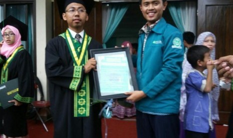 Presiden BEM KBM STEI SEBI Ihsan Munawwar (kanan) beserta seorang wisudawan dalam prosesi Wisuda XI Kampus STEI SEBI, Sabtu (26/11).