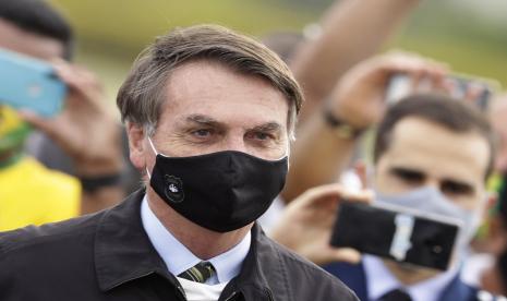 Presiden Brasil Jair Bolsonaro bersama para pendukungnya yang mengajak ia berswafoto di Brasilia, Brasil.