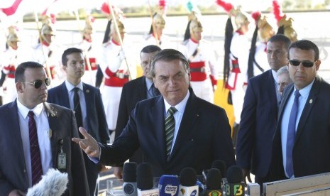 Presiden Brasil Jair Bolsonaro (tengah) berbicara pada wartawan di luar kediaman resmi kepresidenan Alvorada Palace, Brasilia, Brasil, Selasa (27/8).