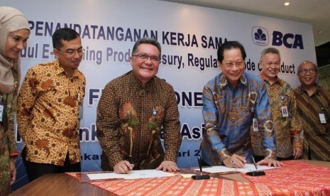 Presiden Direktur BCA Jahja Setiaatmadja (ketiga kanan) dan Ketua Umum ACI FMA Indonesia Branko Windoe (ketiga kiri) menandatangani kerja sama yang disaksikan oleh Direktur BCA Rudy Susanto (kedua kanan), Jakarta, Selasa (7/2). 