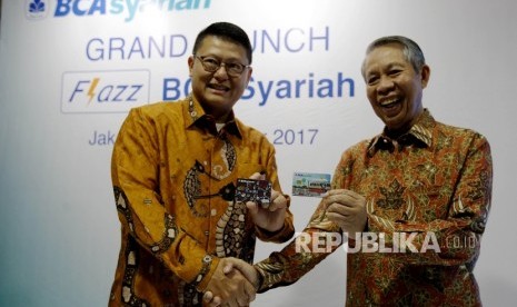 Presiden Direktur BCA Syariah John Kosasih (kiri) bersama Direktur BCA Suwignyo Budiman (kanan) menujukkan kartu uang elektronik Flazz BCA Syariah di Jakarta, Rabu (6/9). 