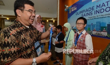 Presiden Direktur Klinik Pendidikan MIPA (KPM) Ridwan Hasan Saputra (kiri) mengalungkan medali emas kepada peserta terbaik mata pelajaran matematika Rafael Kristoforus dalam ajang Olimpiade Matematika dan Sains se-Indonesia (OMSI) 2016