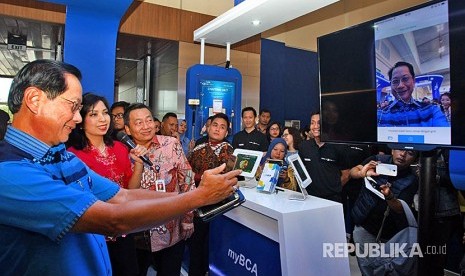 Presiden Direktur PT. Bank Central Asia Tbk (BCA) Jahja Setiaatmadja (kiri) mencoba produk perbankan digital saat  membuka BCA Expoversary 2018 di Indonesia Convention Exebation, Tangerang, Banten, Jumat (9/2). Dalam rangka memperingati hari jadinya yang ke- 61 BCA menghadirkan pameran produk perbankan  mulai dari Kredit perumahan rakyat, kredit kendaraan bermotor dan lainnya dengan bunga ringan. 