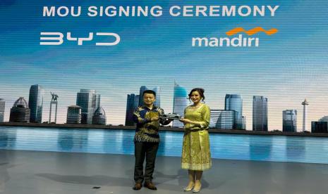 Presiden Direktur PT BYD Motor Indonesia Eagle Zhao (kiri) menyerahkn cindera mata kepada Wakil Direktur Utama Bank Mandiri Alexandra Askandar seusai pendatanganan Memorandum of Understanding (MoU) di arena IIMS 2024 Kemayoran, Jakarta, Kamis (15/2/2024).