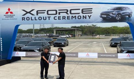 Presiden Direktur PT Mitsubishi Motors Krama Yudha Sales Indonesia (MMKSI) Atsushi Kurita (kanan) merima secara simbolis gambar kunci dari Presiden Direktur PT Mitsubishi Motors Krama Yudha Indonesia (MMKI) Minoru Saito dalam acara Xforce Rollout Ceremony di Cikarang, Jawa Barat, Kamis (16/11/2023).