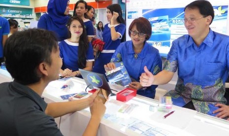 Presiden Direktur XL Dian Siswarini (kiri), disaksikan Chief Brand & Customer Experience Officer XL, Nicanor V. Santiago, mengganti kartu SIM lama milik seorang pelanggan dengan kartu SIM 4G XL di Mall Ambassador, Selasa (17/11). 