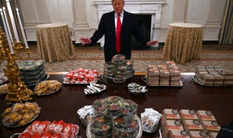 Presiden Donald Trump berbicara kepada media di hadapan hidangan cepat saji yang tersaji bagi tim Clemson Tigers di Gedung Putih, Senin (14/1) waktu AS.