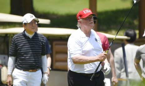 Presiden Donald Trump (kanan) bermain golf dengan PM Jepang, Shinzo Abe, di Mobara Country Club di Mobara, selatan Tokyo, Ahad (26/5).