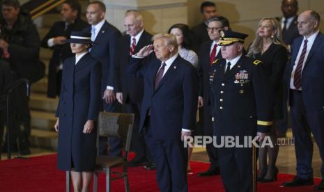 Presiden Donald Trump, tengah, bersama ibu negara Melania Trump, kiri, memberi hormat di Emancipation Hall setelah Pelantikan Presiden ke-60 di Gedung DPR AS di Washington, Senin, 20 Januari 2025.