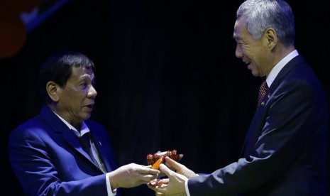 Presiden Filipina Rodrigo Duterte menyerahkan keketuaan ASEAN kepada Perdana Menteri Singapura Lee Hsien Loong saat penutupan KTT ASEAN ke-31 di Manila, Filipina, Selasa (14/11).