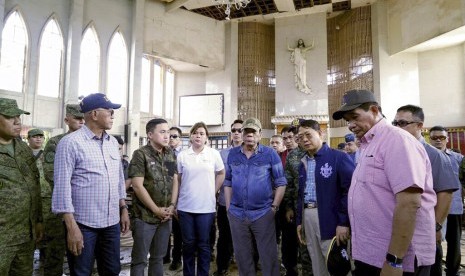 Presiden Filipina Rodrigo Duterte (tengah) mengunjungi Gereja Katedral Katolik di Jolo, Provinsi Sulu, Filipina, Senin (28/1). Kunjungan dilakukan dua hari setelah dua bom meledak saat Misa Ahad. 