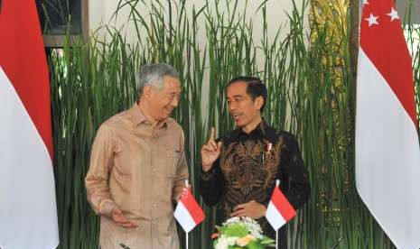 Indonesian President Joko Widodo (right) talks with Singapore Prime Minister Lee Hsien Loong (left) before the signing of bilateral cooperation between Indonesian and Singaporean ministers, on the sidelines of the IMF Annual Meeting - World Bank Group 2018 in Nusa Dua, Bali, Thursday (Oct 11).