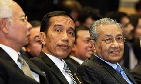  Presiden Indonesia Joko Widodo, tengah, duduk di samping Chairman Proton Holdings Bhd. Mahathir Mohamad (kanan) dan Perdana Menteri Malaysia Najib Razak jelang penandatanganan nota kesepahaman antara Proton and PT Adiperkasa Citra Lestari, di Shah Alam, M