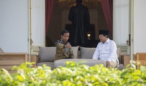 Presiden Joko Widodo berbincang dengan Ketua Umum DPP Partai Gerakan Indonesia Raya Prabowo Subianto (kanan) di teras belakang Istana Merdeka, Jakarta, Kamis (17/11).